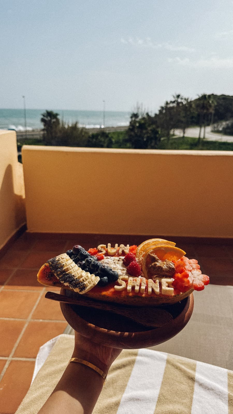 Un bowl de açaí con fruta frente a una vista al mar desde un balcón en Marbella