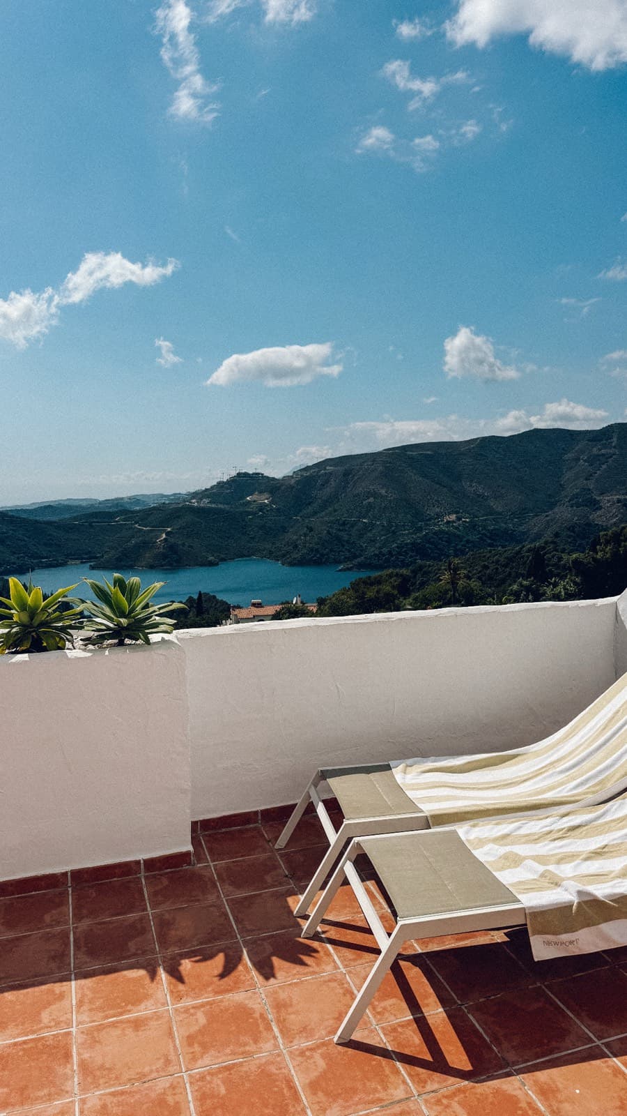 Terrass med solstolar och utsikt över berg och en sjö i Marbella