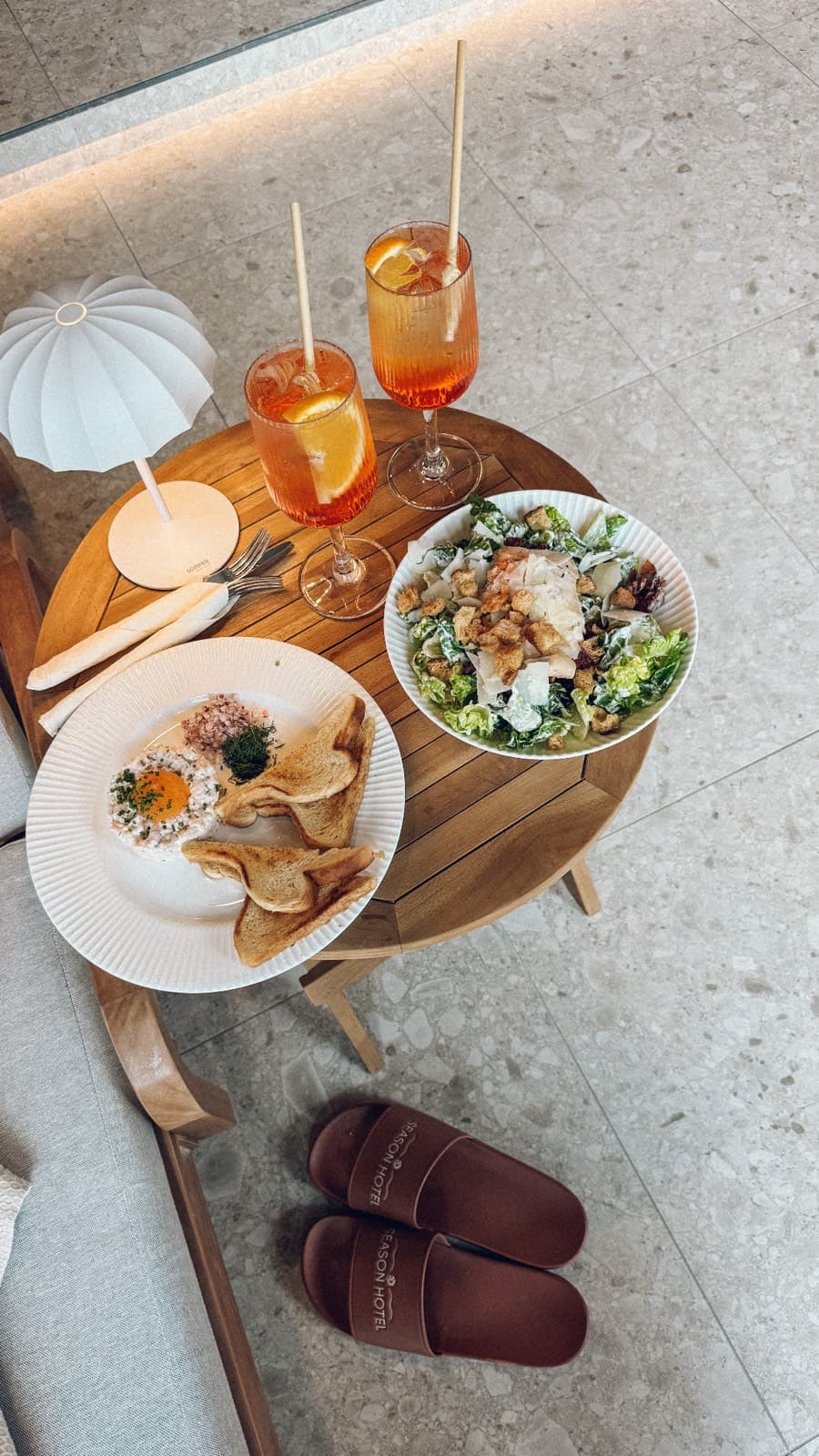 Uppdukad brunch med spritz och sallad sedd uppifrån på ett hotell